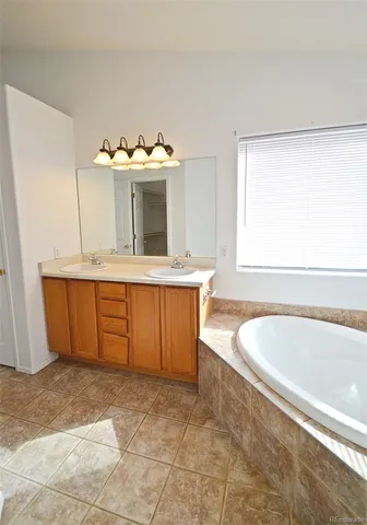 a spacious bathroom with a tub sink and mirror