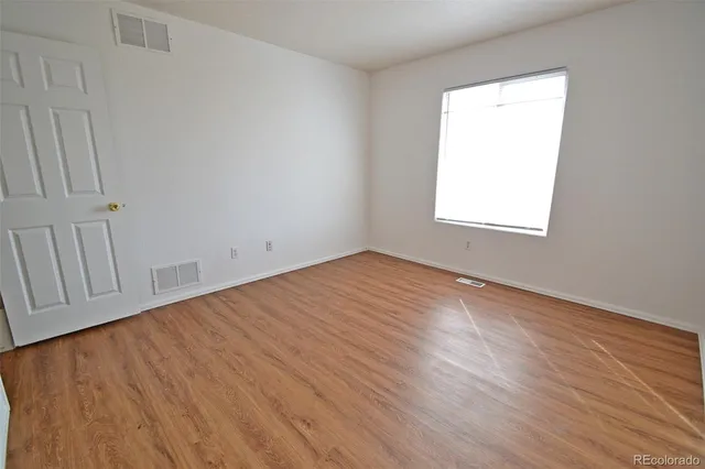 a view of an empty room with wooden floor