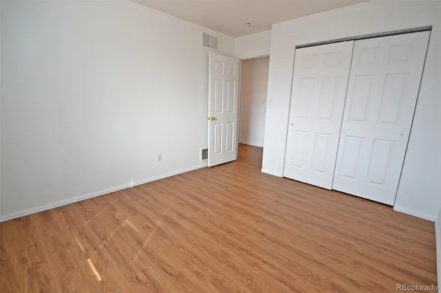 an empty room with wooden floor and entrance