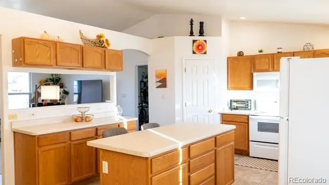 a kitchen with a sink a refrigerator and white cabinets