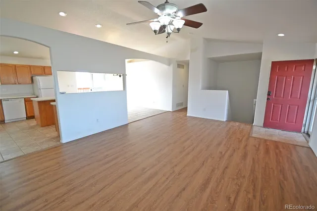 a view of an empty room with window and wooden floor