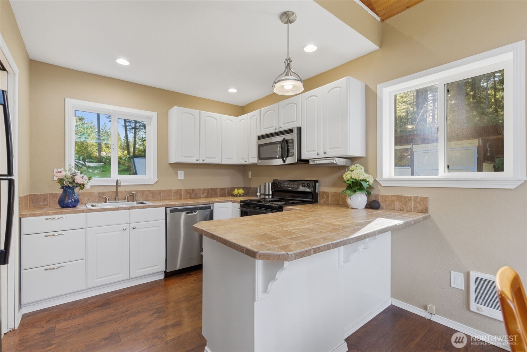 6971 Northeast Tahuya Blacksmith Road Belfair, WA 98528 - Photo 16 of 38 a kitchen with a stove a sink a center island and a window