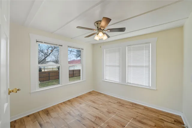 a view of an empty room with a window and closet area