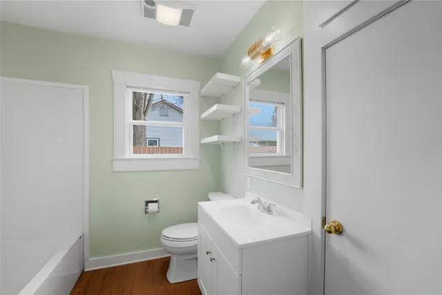 a bathroom with a toilet sink and mirror