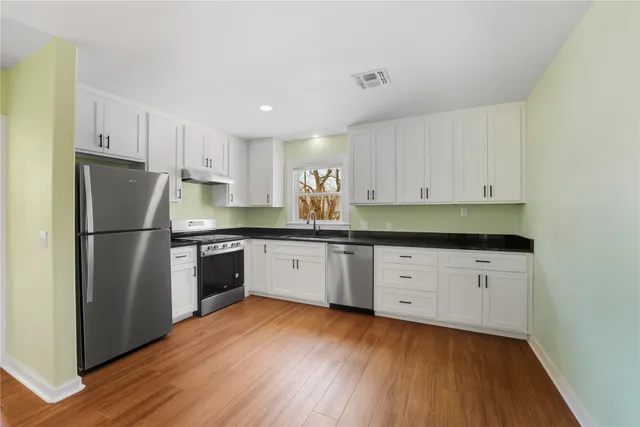 a kitchen with stainless steel appliances a refrigerator sink and cabinets