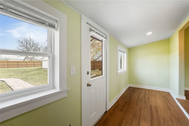 a view of hallway with a large window and wooden floor