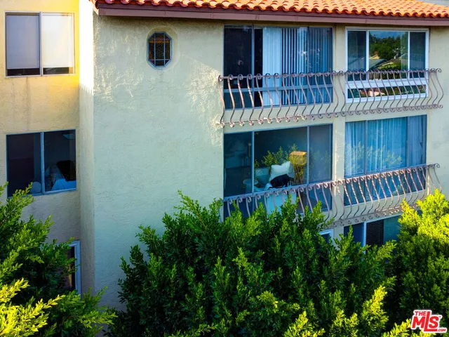 a view of house with balcony and outdoor seating