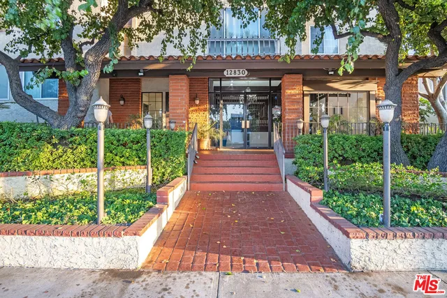 a front view of a house with a garden and plants