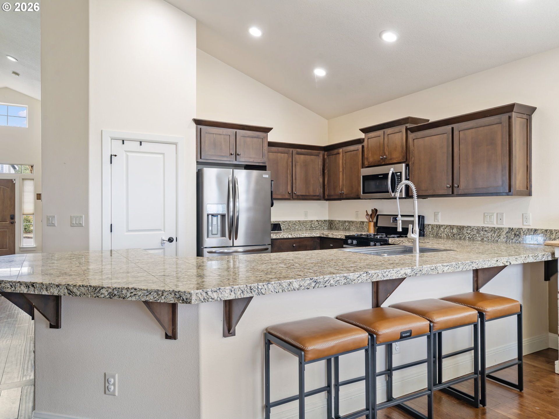 4081 Southwest Binford Avenue Gresham, OR 97080 - Photo 14 of 43 a kitchen with stainless steel appliances granite countertop a refrigerator a stove a sink a dining table and chairs