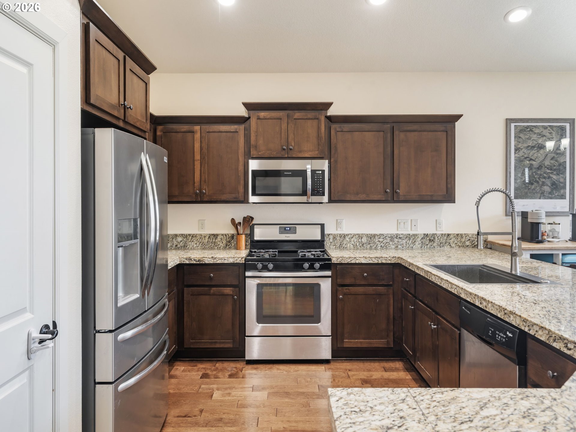 4081 Southwest Binford Avenue Gresham, OR 97080 - Photo 15 of 43 a kitchen with stainless steel appliances granite countertop a stove top oven a sink and a refrigerator with wooden cabinets