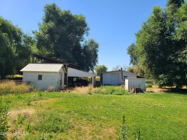 a front view of a house with yard and trees