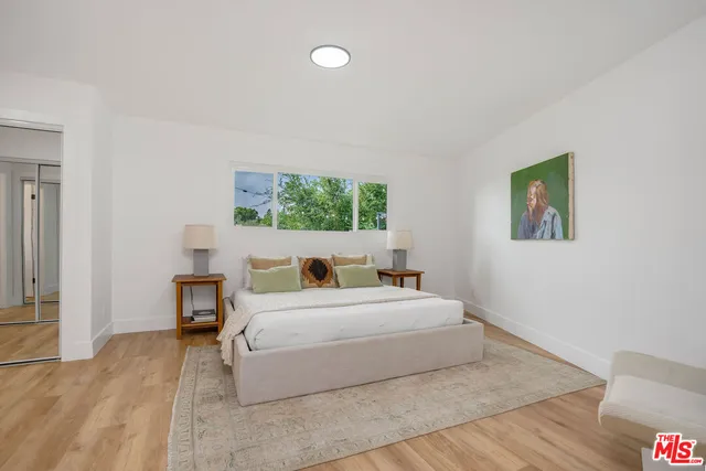 a bedroom with a bed and a painting on the wall