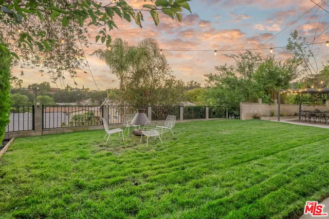 a view of a house with backyard and sitting area