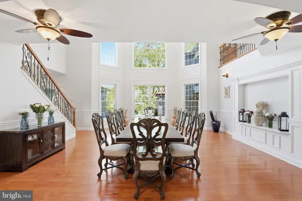 a kitchen with stainless steel appliances granite countertop a stove a sink dishwasher a refrigerator and a dining table with wooden floor
