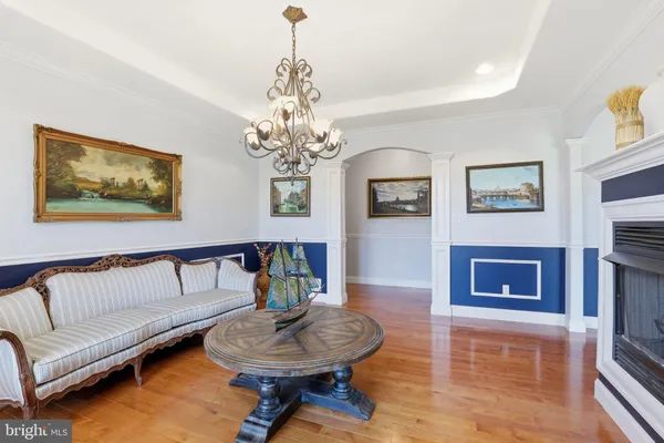 a bedroom with a bed a chandelier and dresser