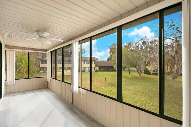 a view of an empty room with wooden floor and a large window