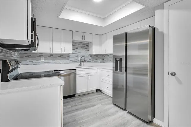 a kitchen with a refrigerator sink and cabinets