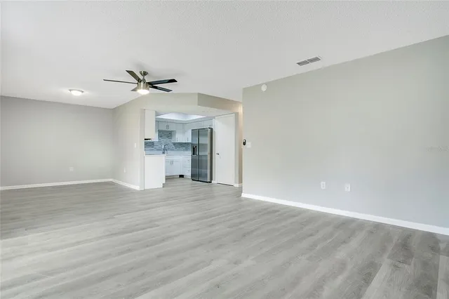 a view of empty room with wooden floor and window