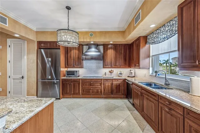 a kitchen with stainless steel appliances granite countertop a sink refrigerator and cabinets