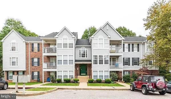 a front view of a residential apartment building with a yard