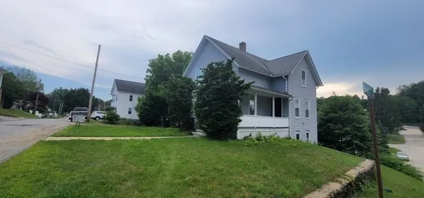 a view of a house with a big yard plants and large trees