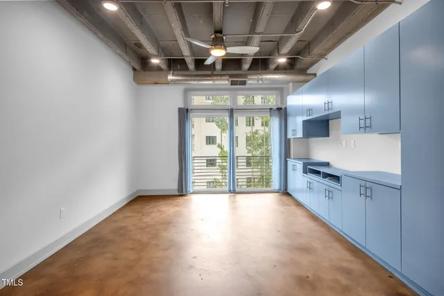 a view of a kitchen with stainless steel appliances granite countertop a stove and a large window