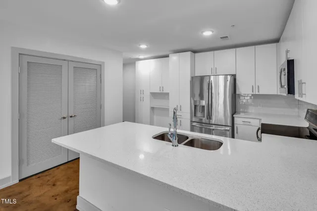 a kitchen with stainless steel appliances a refrigerator and wooden cabinets