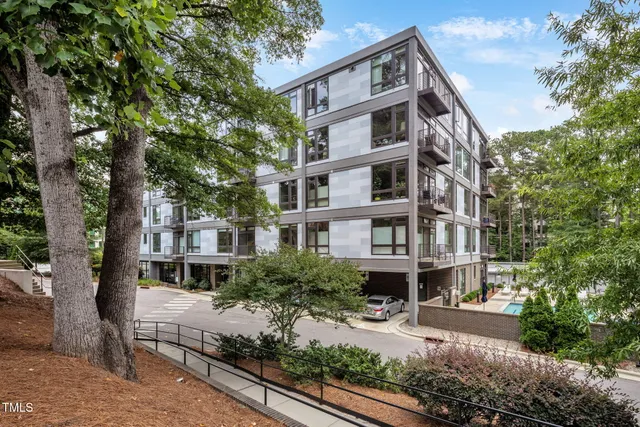 a view of a building with a bench and trees around