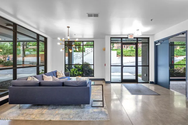 a living room with furniture and large windows