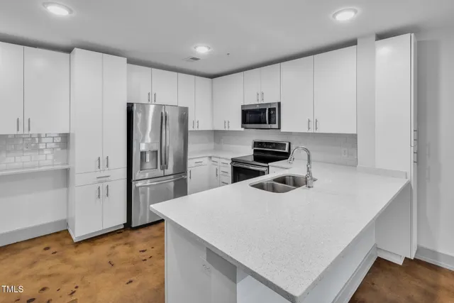 a kitchen with a refrigerator a microwave a sink and cabinets