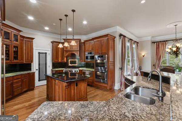 a kitchen with stainless steel appliances granite countertop a stove a sink and a refrigerator