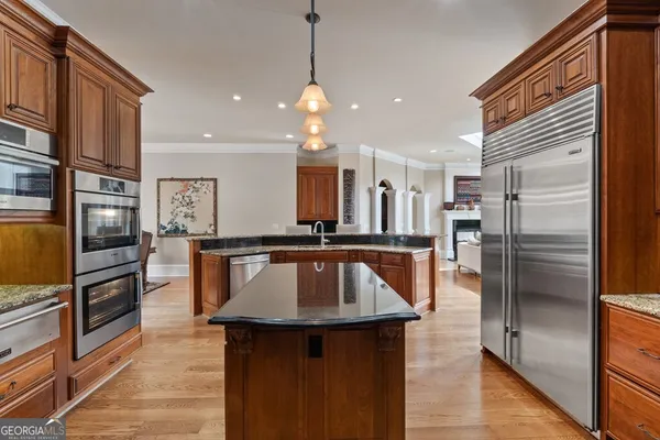 a living room with furniture kitchen view and a chandelier
