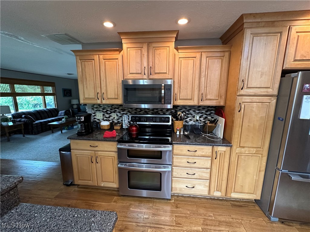 354 Big Bass Road Willard, OH 44890 - Photo 12 of 29 Kitchen with tasteful backsplash, light brown cabinets, appliances with stainless steel finishes, and carpet floors