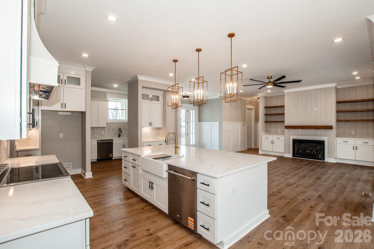4453 Brancer Lane, Unit 4 Lincolnton, NC 28092 - Photo 15 of 48 a large kitchen with kitchen island a stove a sink dishwasher and a fireplace with wooden floor