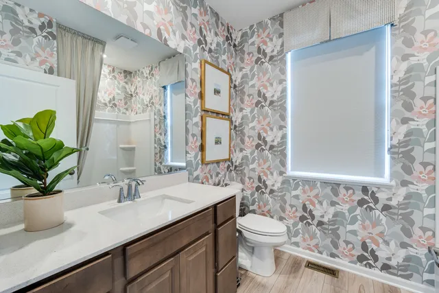 a bathroom with a granite countertop sink a toilet and a mirror