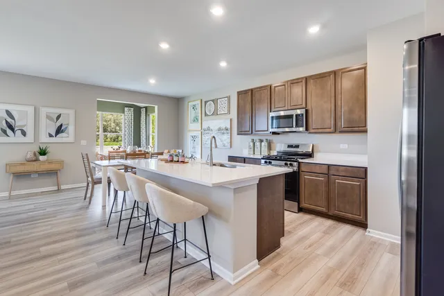 a kitchen with a table chairs a sink dishwasher stove and cabinets with wooden floor