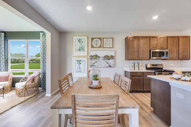 a kitchen with granite countertop a stove a sink a dining table and chairs