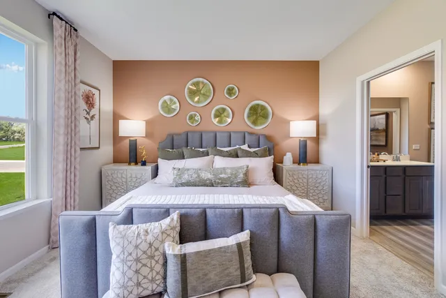 a bedroom with a bed and a dresser next to a window