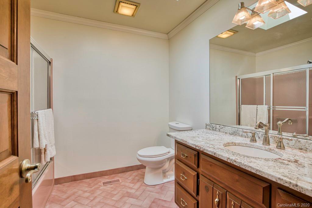 14 Holly Ridge Lane Tryon, NC 28782 - Photo 25 of 42 a bathroom with a granite countertop sink a toilet and a mirror