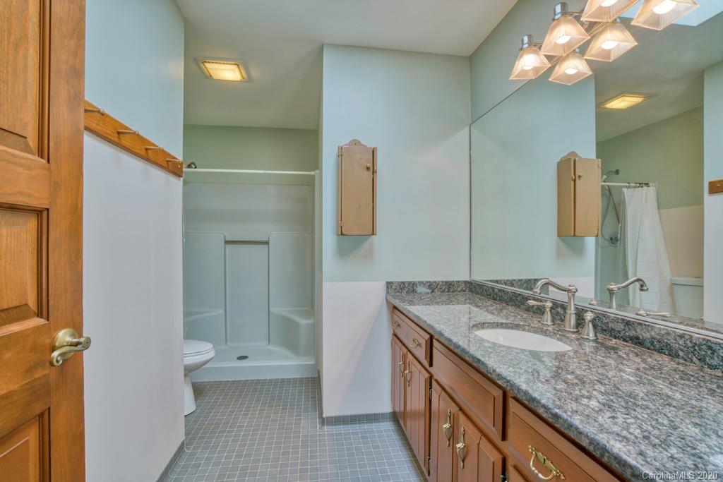 14 Holly Ridge Lane Tryon, NC 28782 - Photo 26 of 42 a bathroom with a granite countertop sink a large mirror and a shower