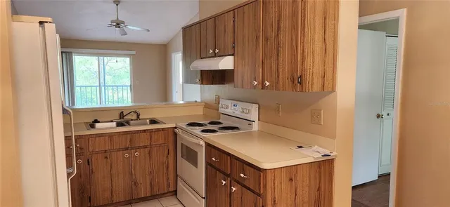 a bathroom with a refrigerator sink and cabinets