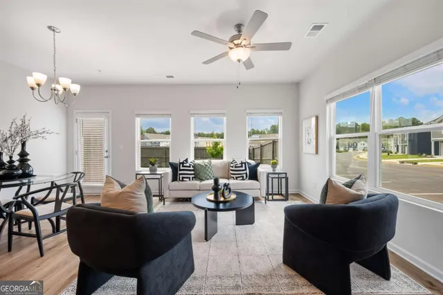 a living room with furniture potted plant and a chandelier