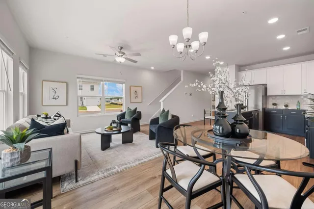 a view of a dining room with furniture a chandelier and wooden floor