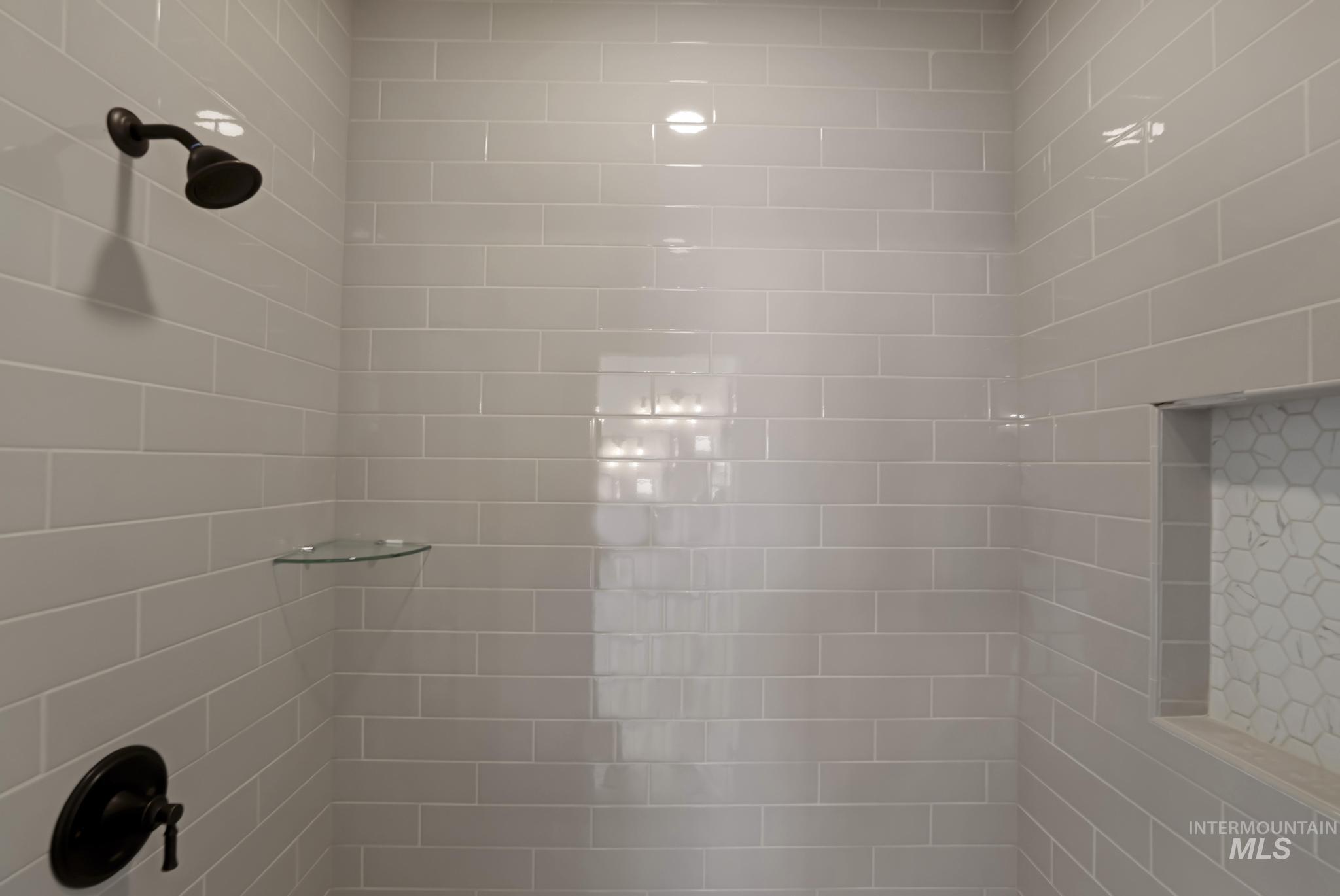 866 Quartz Road Kimberly, ID 83341 - Photo 23 of 48 Shower with subway tile walls, oil-rubbed bronze shower head, built-in glass corner shelf, oil-rubbed bronze shower control, and a recessed niche with hexagonal tile