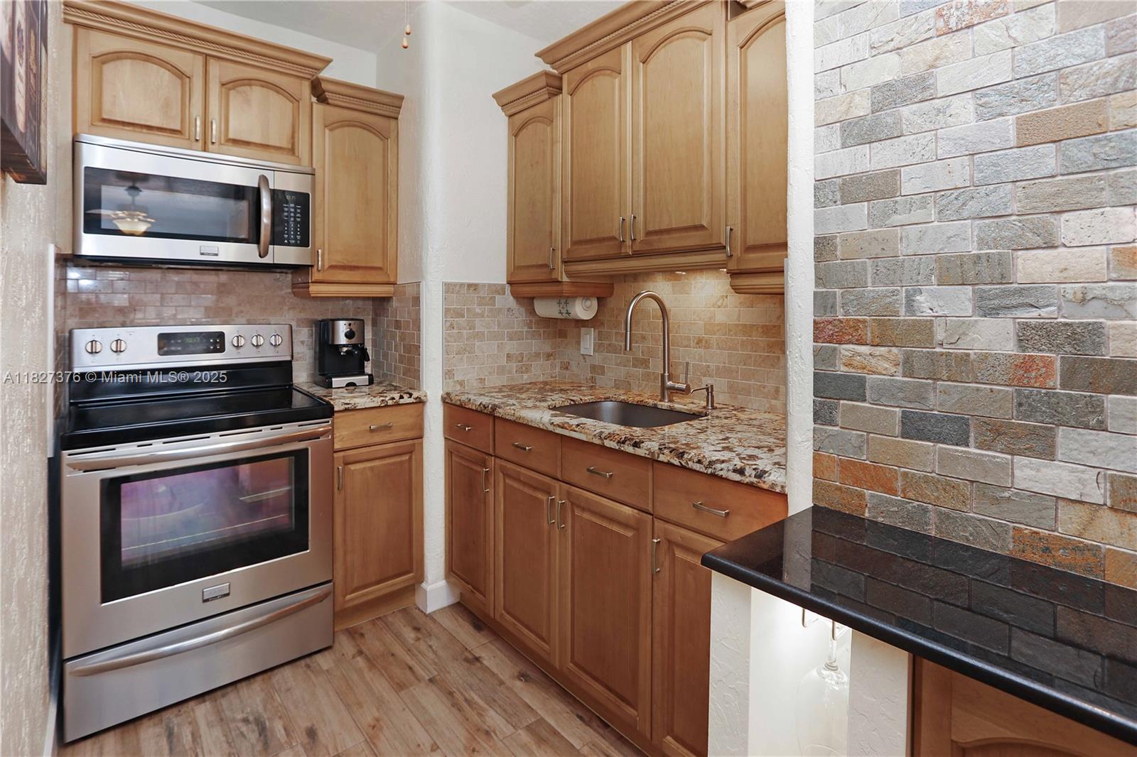 3300 North Surf Road, Unit 3A Hollywood, FL 33019 - Photo 12 of 39 a kitchen with stainless steel appliances granite countertop a stove microwave and refrigerator