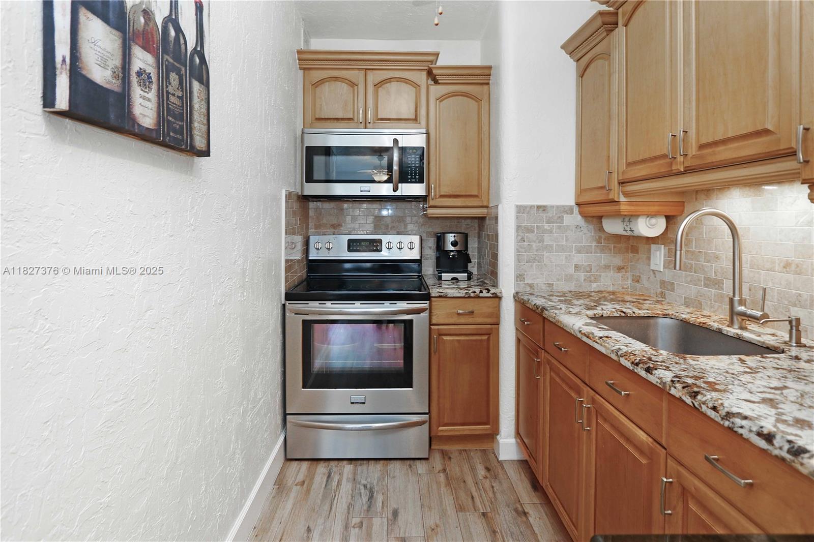3300 North Surf Road, Unit 3A Hollywood, FL 33019 - Photo 13 of 39 a kitchen with stainless steel appliances granite countertop a stove a sink and a microwave