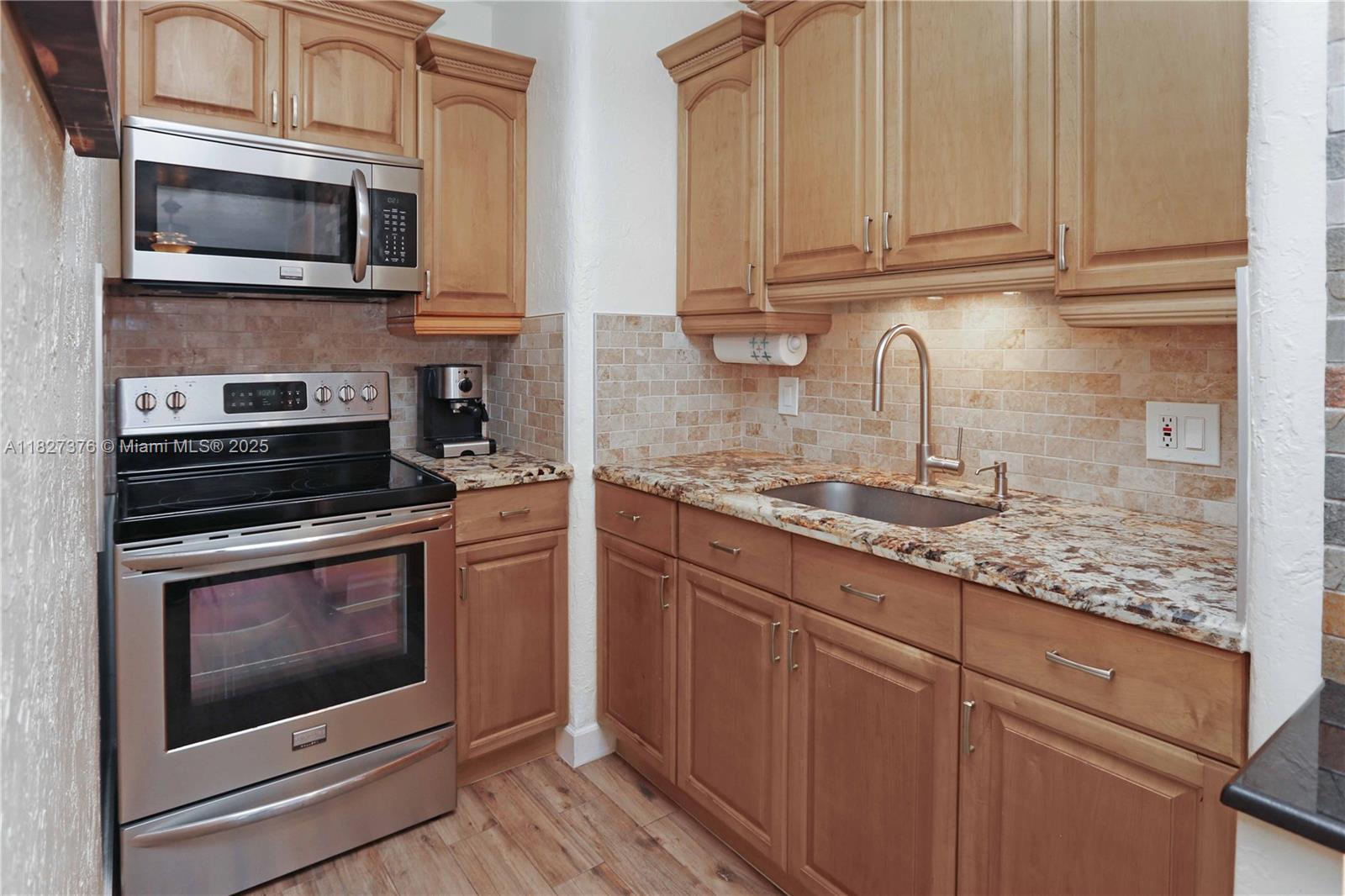 3300 North Surf Road, Unit 3A Hollywood, FL 33019 - Photo 15 of 39 a kitchen with stainless steel appliances granite countertop a stove microwave and cabinets