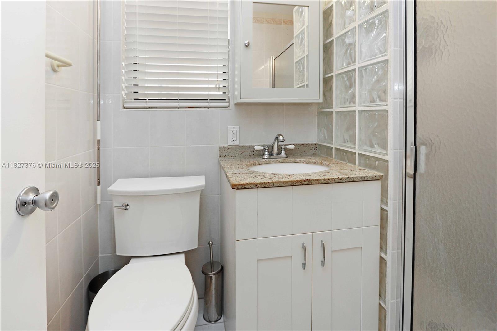 3300 North Surf Road, Unit 3A Hollywood, FL 33019 - Photo 21 of 39 a bathroom with a toilet sink and mirror