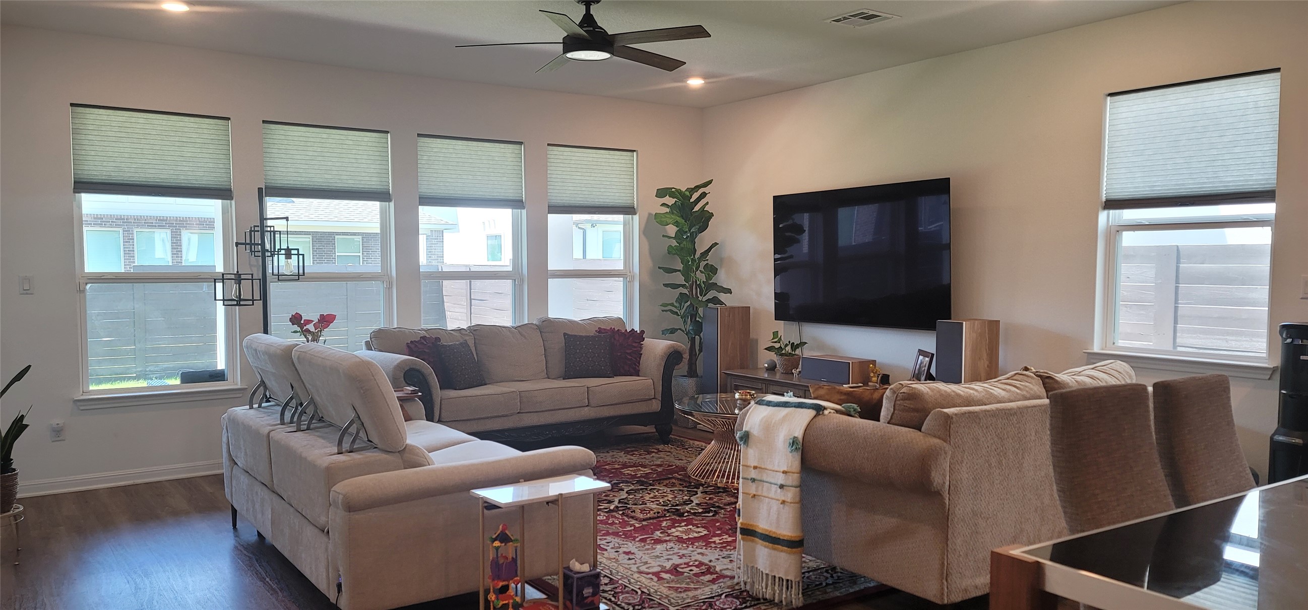 716 Leeward Pass Leander, TX 78641 - Photo 4 of 26 A well-lit gathering space with ample seating, rich wood flooring, and modern overhead illumination.