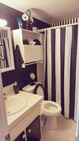 a bedroom with a bed and a dresser next to a window